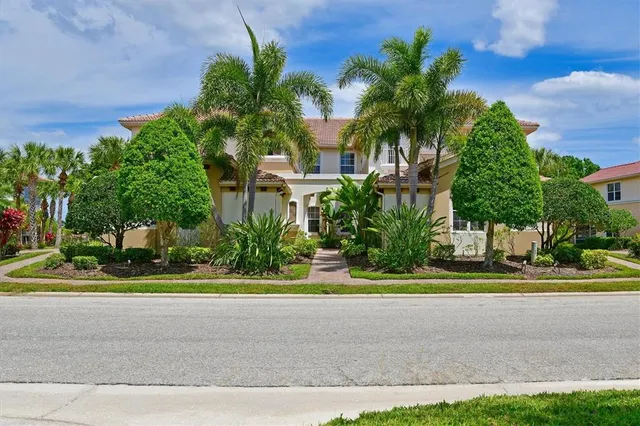 a front view of a house with a yard and fountain