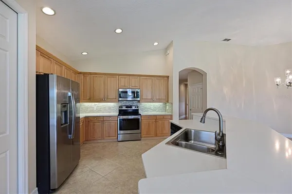 a kitchen with stainless steel appliances kitchen island a sink stove and refrigerator