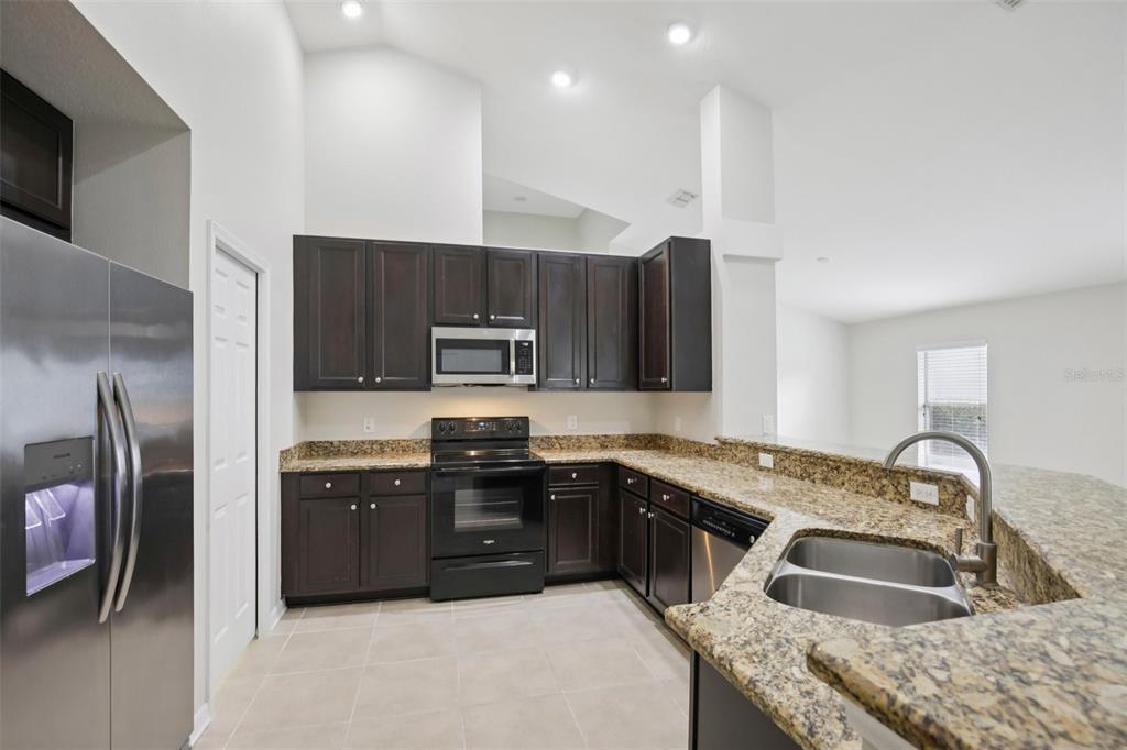 106 Star Shell Drive Apollo Beach, FL 33572 - Photo 11 of 33 a kitchen with stainless steel appliances granite countertop a sink stove and refrigerator