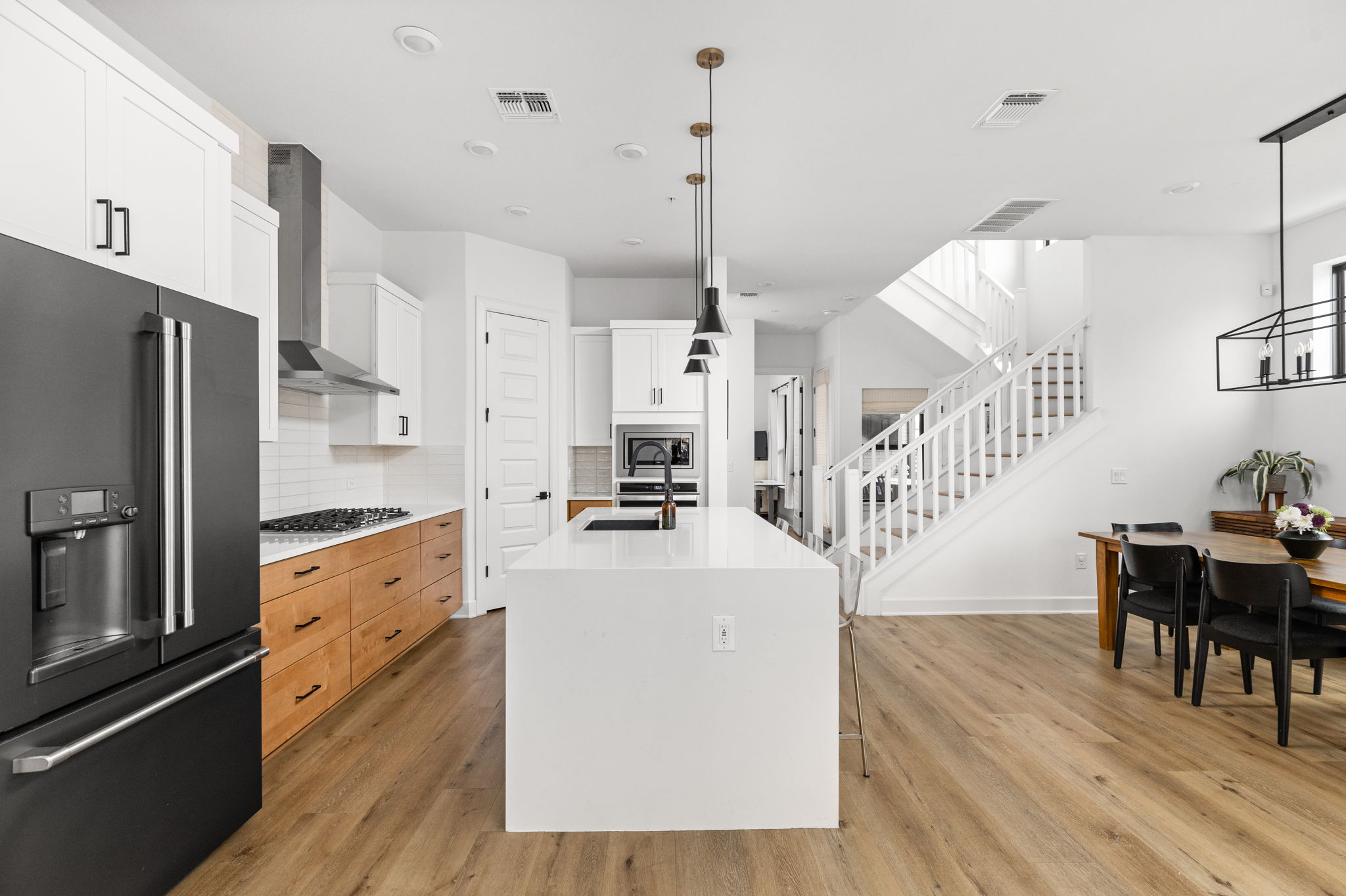 4710 Eberly Street Austin, TX 78723 - Photo 7 of 36 a kitchen with stainless steel appliances kitchen island granite countertop a refrigerator a stove oven and white cabinets with wooden floor