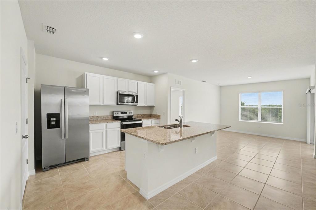 2795 Grandbury Grove Road Lakeland, FL 33811 - Photo 13 of 35 a kitchen with stainless steel appliances granite countertop a sink stove and refrigerator