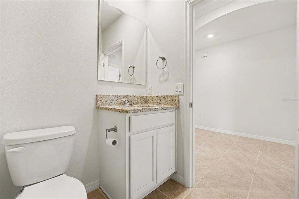 2795 Grandbury Grove Road Lakeland, FL 33811 - Photo 23 of 35 a bathroom with a toilet a sink and mirror