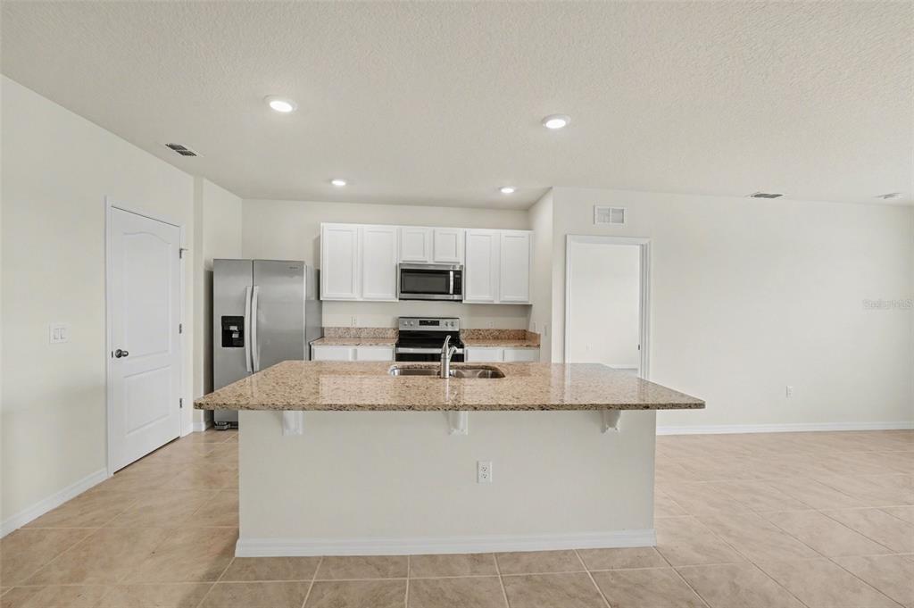 2795 Grandbury Grove Road Lakeland, FL 33811 - Photo 10 of 35 a large kitchen with stainless steel appliances granite countertop a large counter top a stove and a refrigerator
