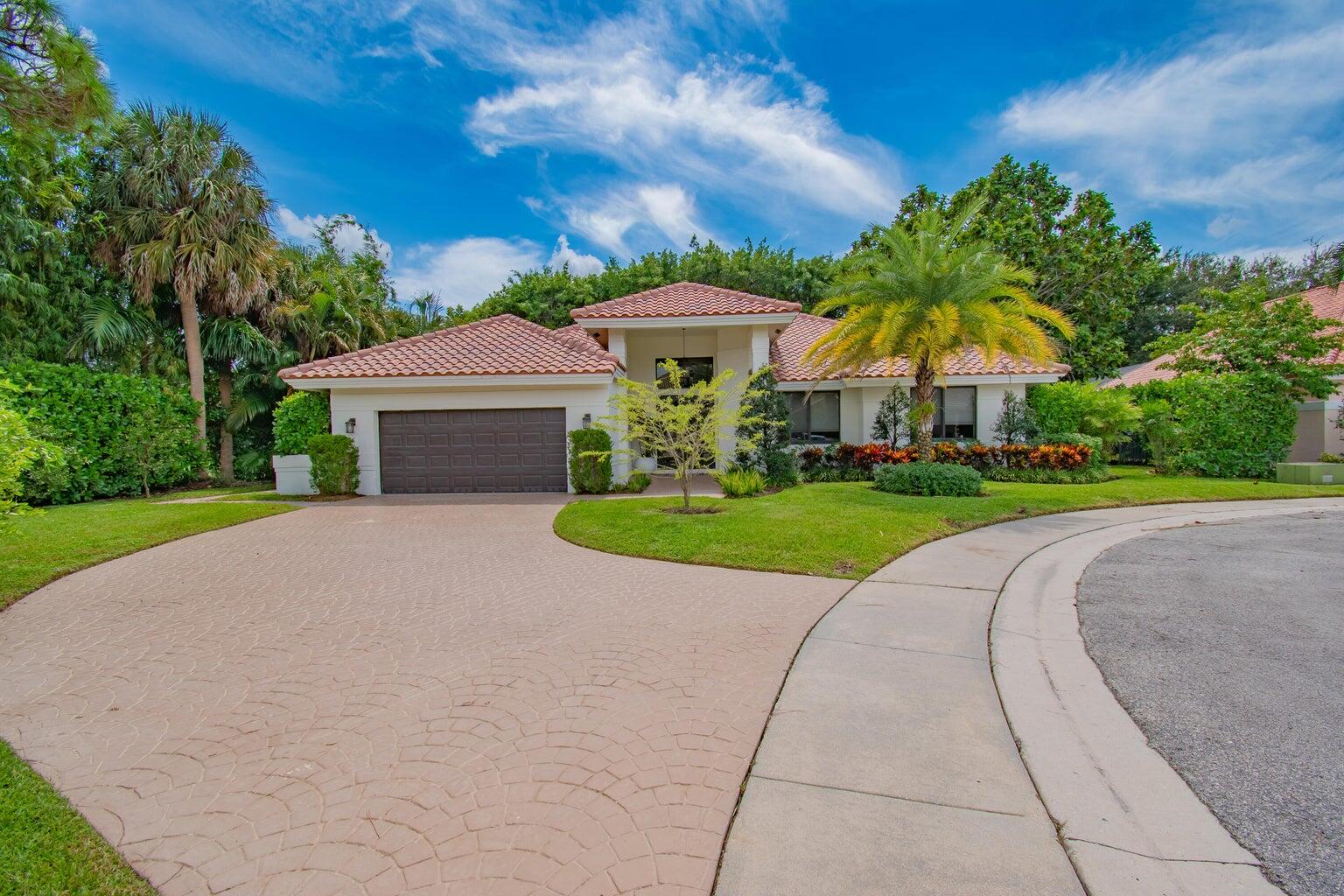 2302 Northwest 66th Drive Boca Raton, FL 33496 - Photo 1 of 53 a view of a house with a yard and table and chairs under an umbrella
