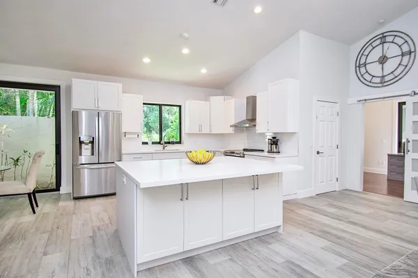 a kitchen with granite countertop white cabinets and white appliances