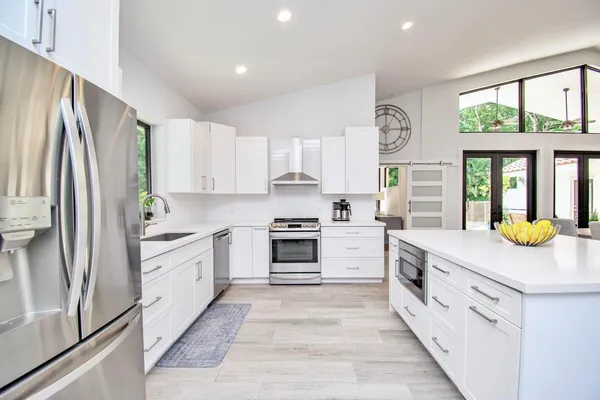 a kitchen with white cabinets and white appliances