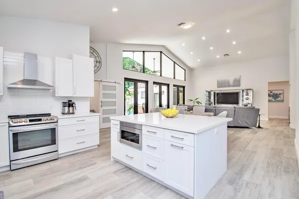 a kitchen that has a sink stainless steel appliances and cabinets