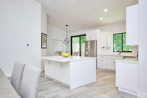 a kitchen with white cabinets and white appliances