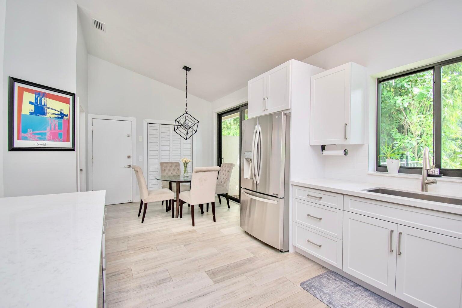 2302 Northwest 66th Drive Boca Raton, FL 33496 - Photo 25 of 53 a kitchen with white cabinets and white appliances