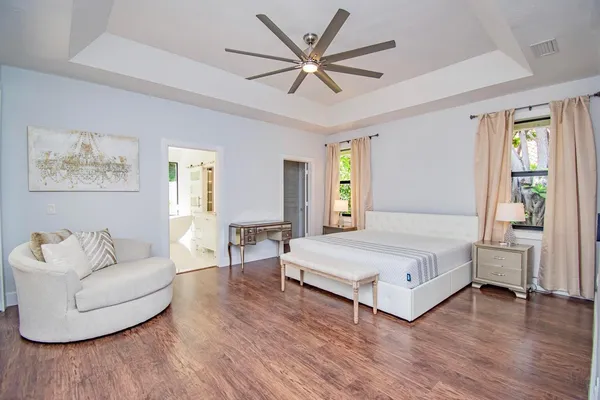 a spacious bedroom with a bed and a chandelier