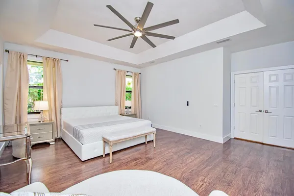 a bedroom with a large bed and wooden floor