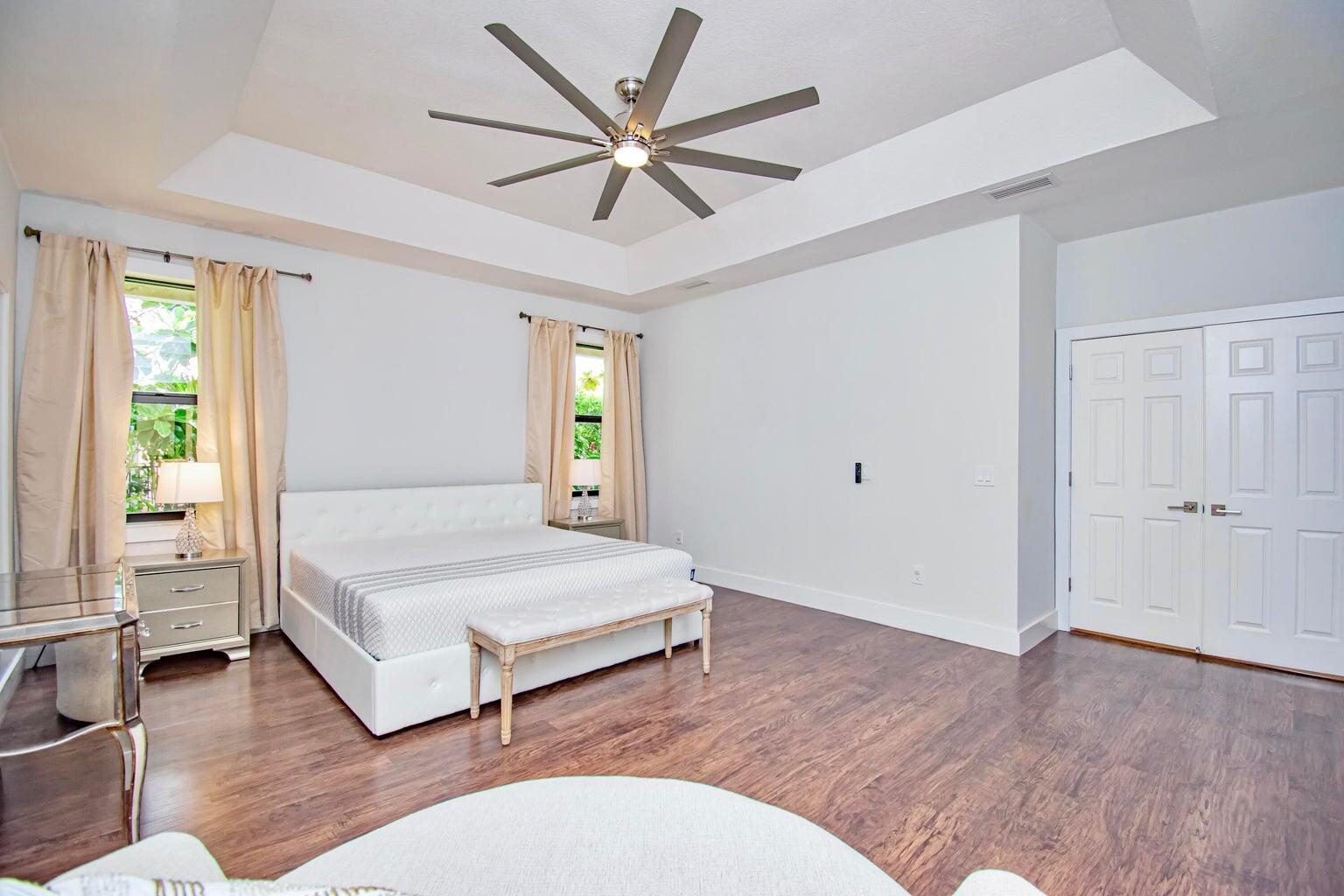 2302 Northwest 66th Drive Boca Raton, FL 33496 - Photo 28 of 53 a spacious bedroom with a bed and a chandelier