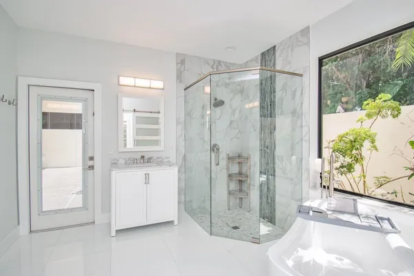 a bathroom with a double vanity sink a mirror and a bathtub