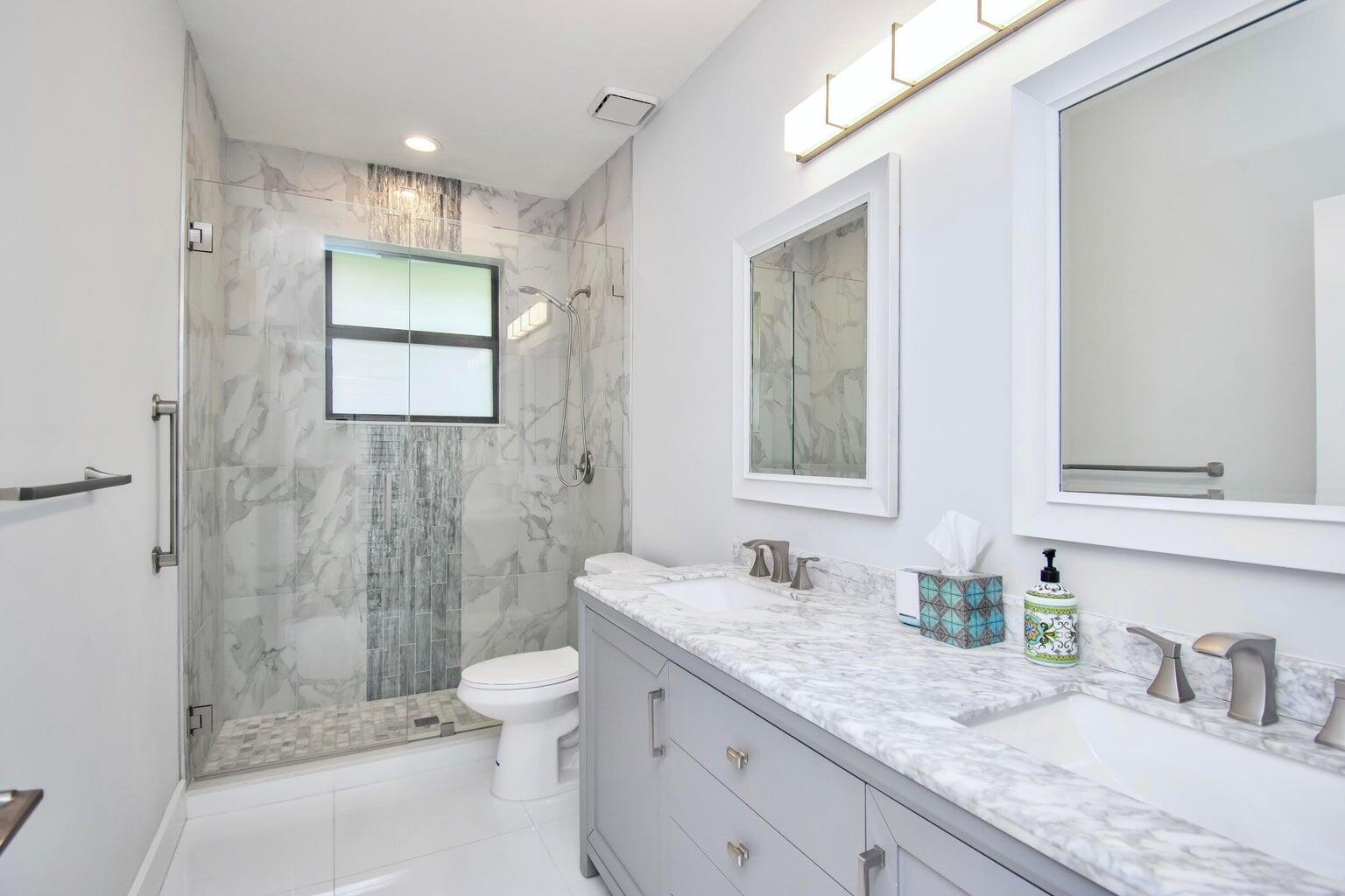 2302 Northwest 66th Drive Boca Raton, FL 33496 - Photo 36 of 53 a bathroom with a granite countertop sink mirror and shower