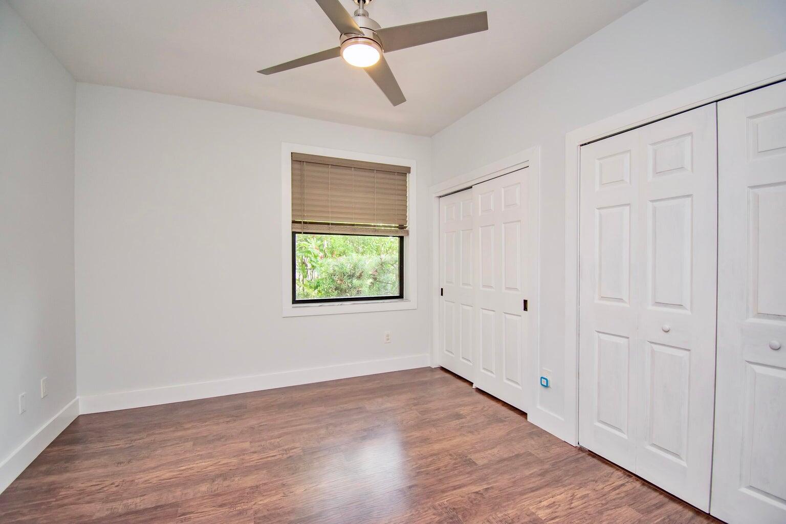 2302 Northwest 66th Drive Boca Raton, FL 33496 - Photo 39 of 53 an empty room with wooden floor chandelier fan and windows