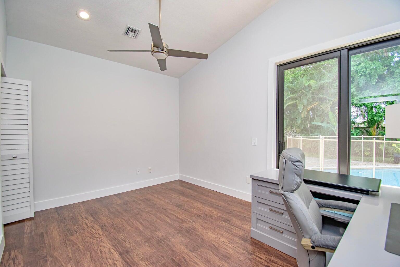 2302 Northwest 66th Drive Boca Raton, FL 33496 - Photo 41 of 53 a view of a room with wooden floor white walls and a window