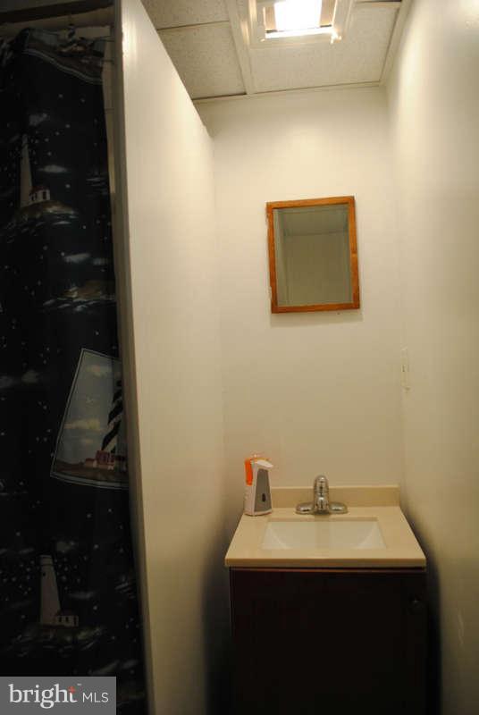8174 Kavanagh Road Baltimore, MD 21222 - Photo 17 of 19 a bathroom with a sink and mirror