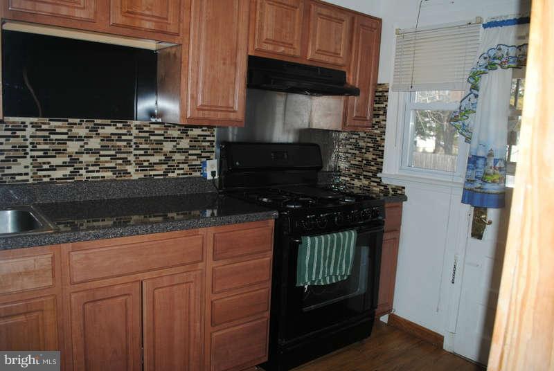 8174 Kavanagh Road Baltimore, MD 21222 - Photo 8 of 19 a kitchen with granite countertop a stove and a microwave