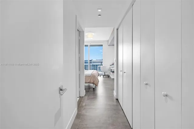 a bedroom with a bed a desk and a large window