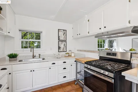 a kitchen with white cabinets and appliances