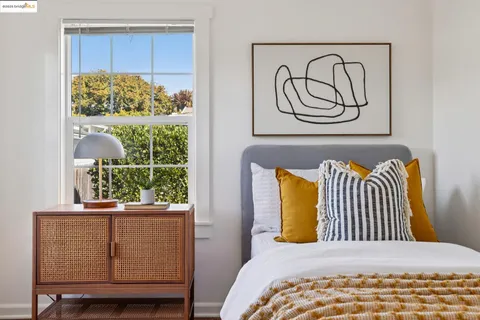 a bedroom with a bed and painting on the wall