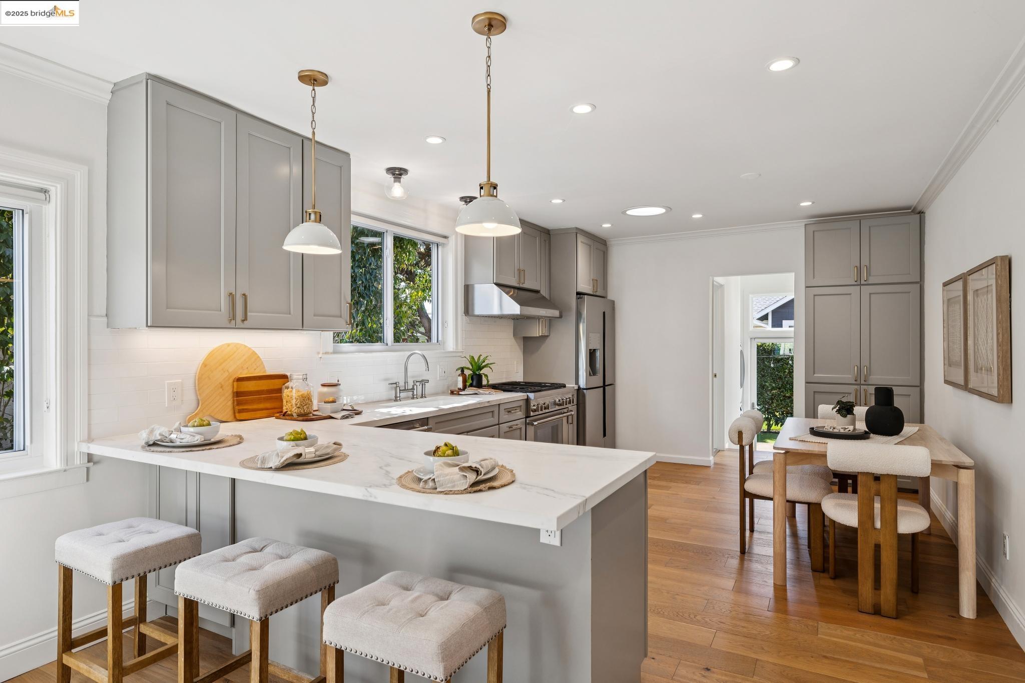 1642 Tenth Street Berkeley, CA 94710 - Photo 8 of 51 a kitchen with stainless steel appliances kitchen island granite countertop a table chairs and a refrigerator