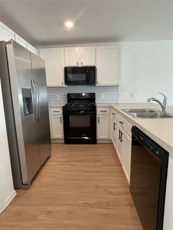 a kitchen with stainless steel appliances a refrigerator and a stove top oven