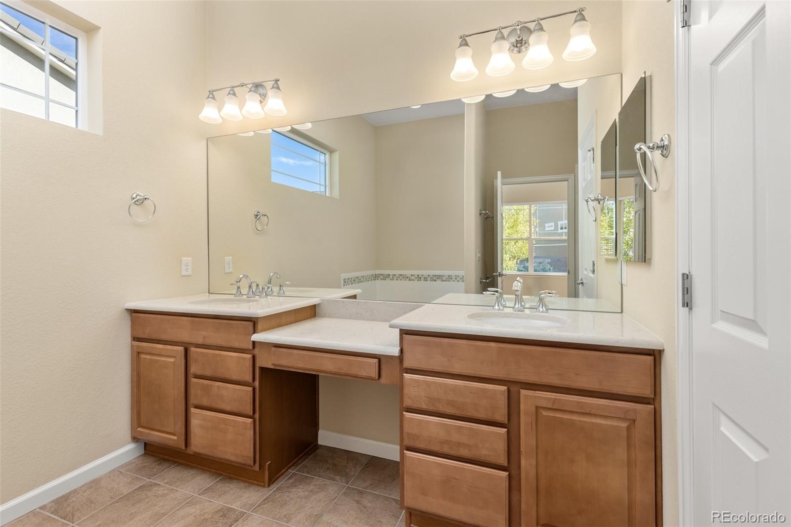 15965 Redcloud Way Broomfield, CO 80023 - Photo 18 of 49 a bathroom with a sink vanity and a mirror