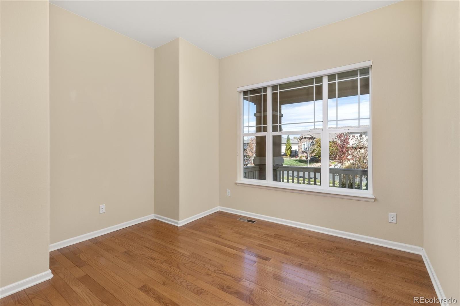 15965 Redcloud Way Broomfield, CO 80023 - Photo 21 of 49 a view of an empty room with wooden floor and a window
