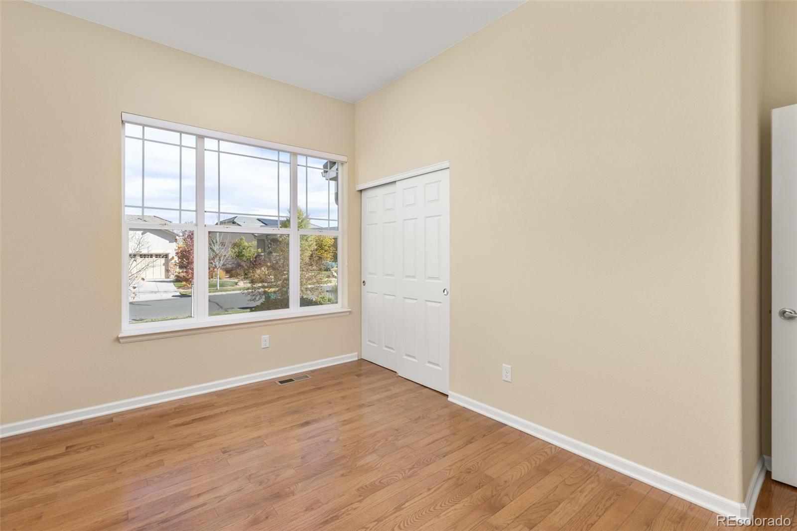 15965 Redcloud Way Broomfield, CO 80023 - Photo 23 of 49 an empty room with wooden floor and windows