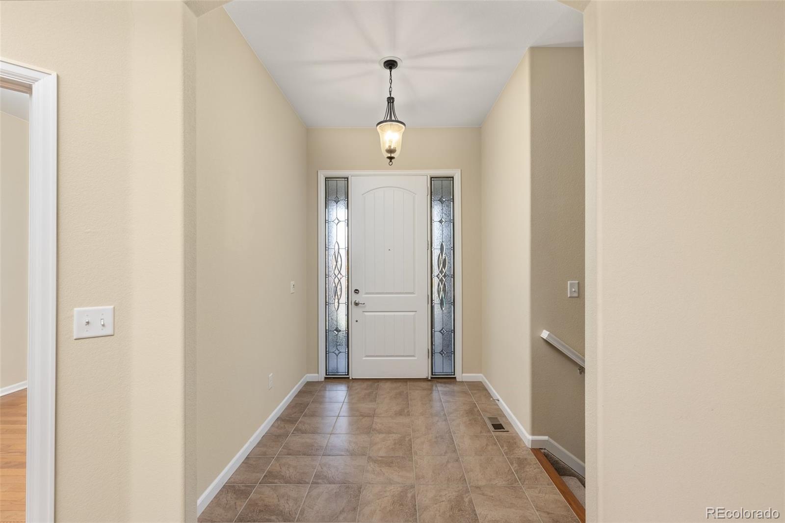 15965 Redcloud Way Broomfield, CO 80023 - Photo 6 of 49 a view of a hallway with wooden floor and a door