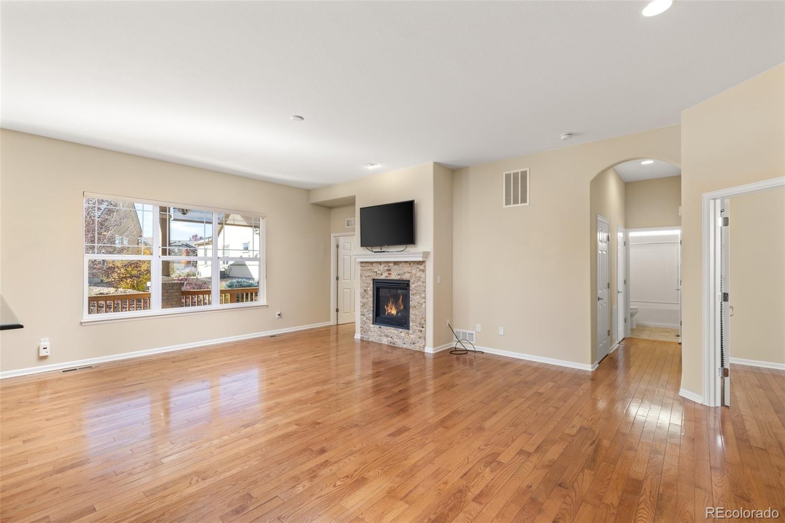 15965 Redcloud Way Broomfield, CO 80023 - Photo 8 of 49 an empty room with wooden floor and a fireplace