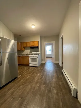 a kitchen with granite countertop a refrigerator and a stove top oven
