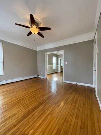 a view of empty room with wooden floor and windows