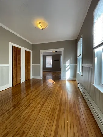 a view of empty room with a fireplace and wooden floor