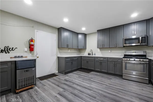 a kitchen with granite countertop a sink cabinets and stainless steel appliances