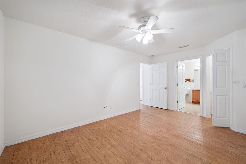 420 Jacks Memorial Road St. Cloud, FL 34769 - Photo 11 of 31 an empty room with wooden floor and fan