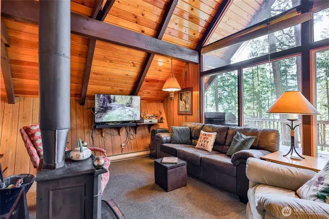a view of a chairs and table on the wooden roof deck