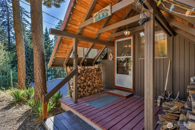 a view of a wooden house with a yard and sitting area