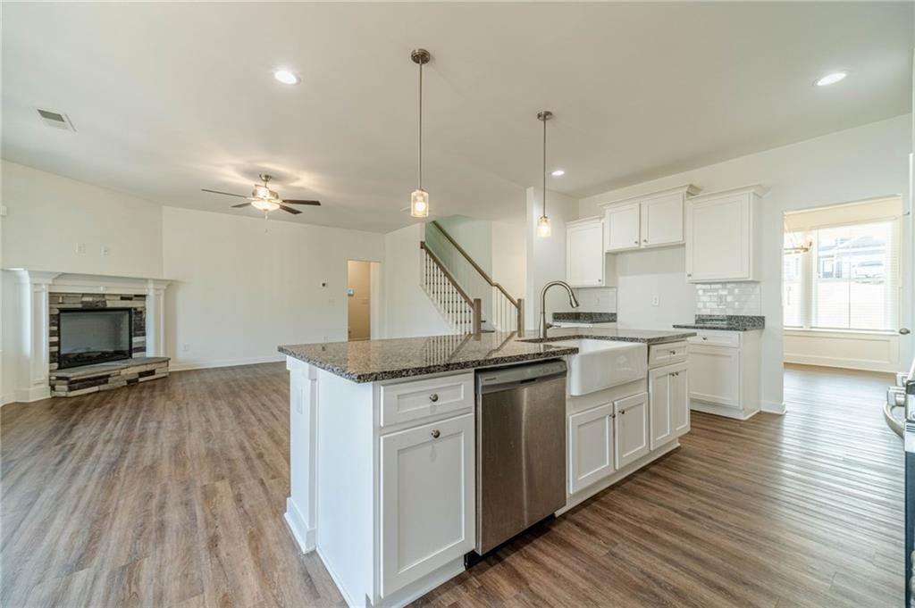1548 Ridgewood Court Monroe, GA 30656 - Photo 16 of 63 a kitchen with granite countertop a sink cabinets and wooden floor