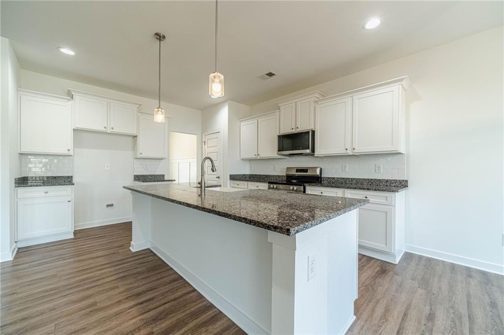 1548 Ridgewood Court Monroe, GA 30656 - Photo 17 of 63 a kitchen with stainless steel appliances granite countertop a sink a stove and a refrigerator