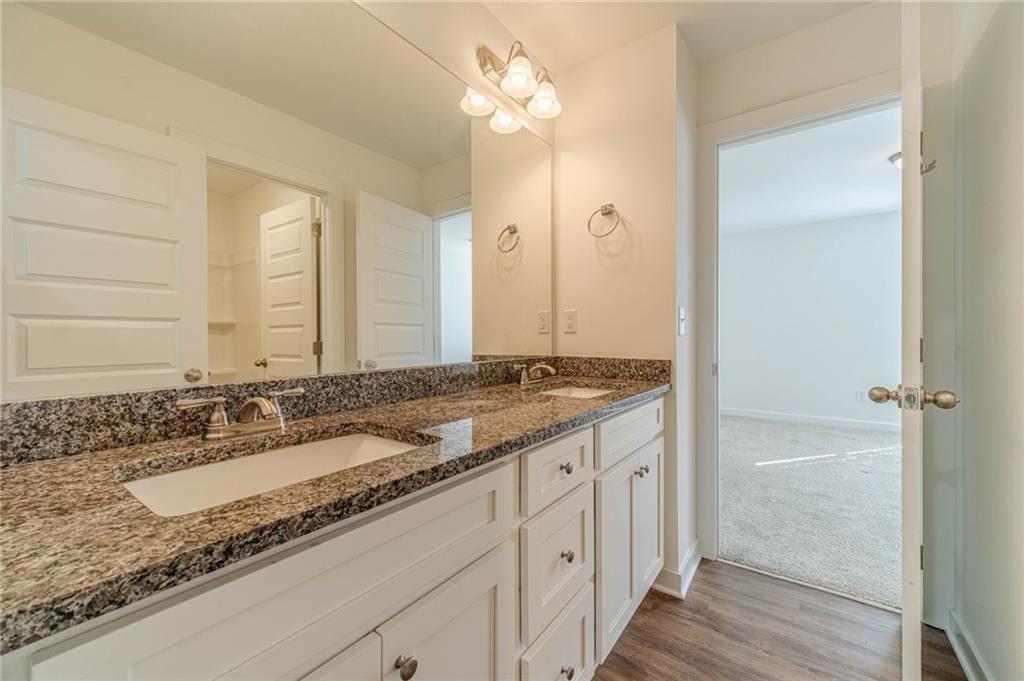 1548 Ridgewood Court Monroe, GA 30656 - Photo 25 of 59 a bathroom with a granite countertop sink and a mirror