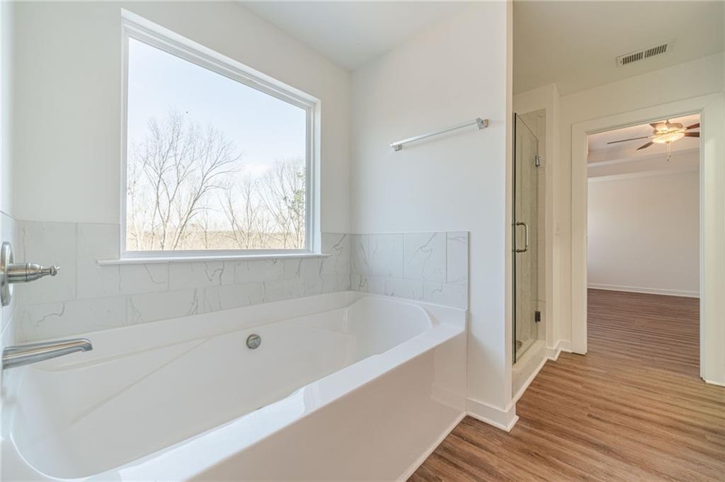 1548 Ridgewood Court Monroe, GA 30656 - Photo 34 of 59 a bathroom with bathtub and a wooden floor