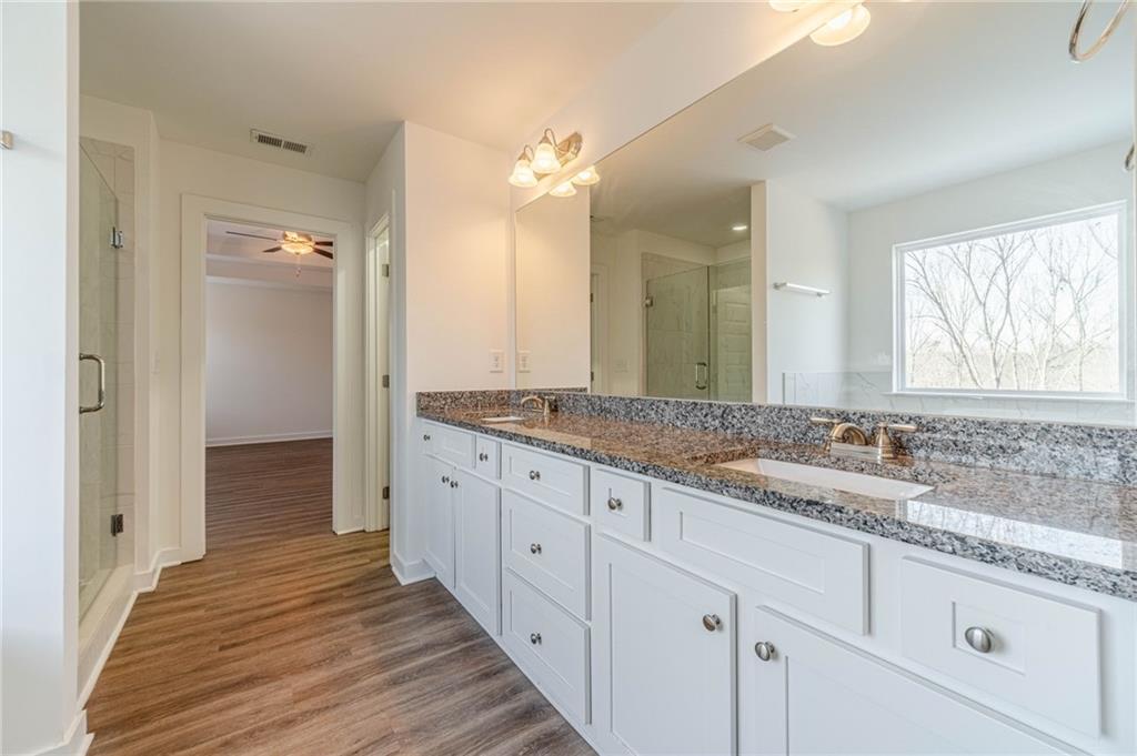 1548 Ridgewood Court Monroe, GA 30656 - Photo 35 of 59 a bathroom with a granite countertop double vanity sink a mirror and a