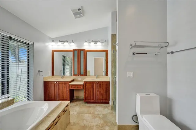 a bathroom with a tub a sink and a large mirror