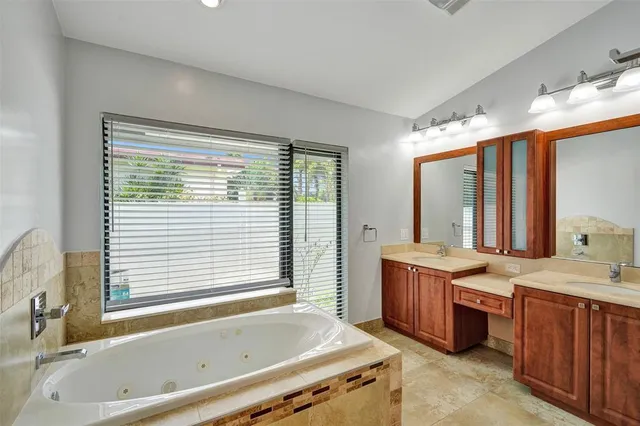 a bathroom with a granite countertop sink and a bathtub