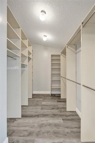 a view of walk in closet with empty racks