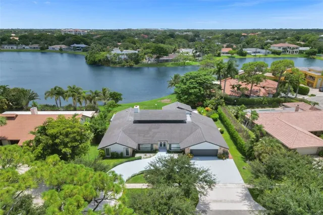 an aerial view of a house with a lake view and a garden