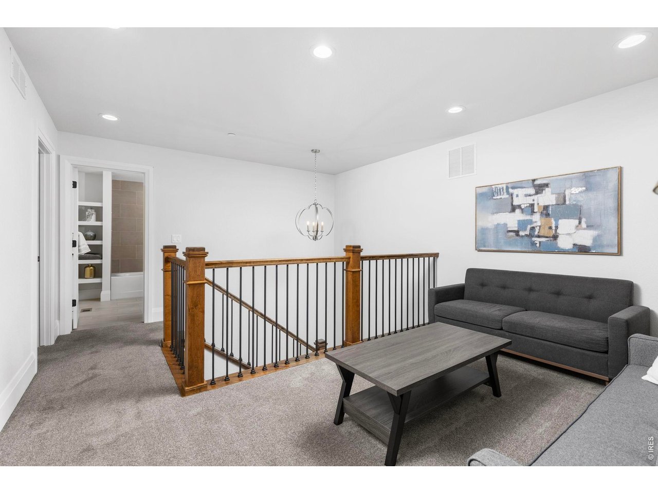 5700 West 2nd Street Road Greeley, CO 80634 - Photo 24 of 40 An open rail staircase with stylish wood bannisters and wrought iron balusters lead up to the second-floor loft