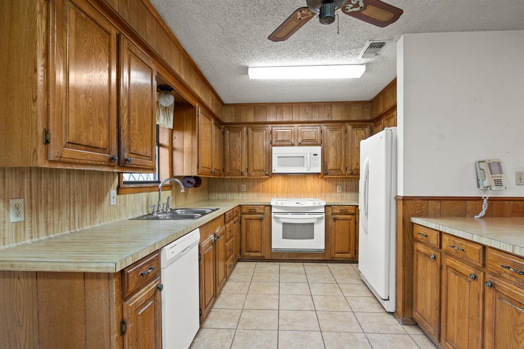 7777 Farm To Market 1001 Cookville, TX 75558 - Photo 10 of 30 a kitchen with a sink stove and refrigerator